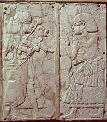 Relief depicting a guard holding a lion cub before the king